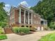 Stately brick home featuring a grand facade with large columns and well-manicured landscaping at 8623 Tullamore Park Cir, Charlotte, NC 28226