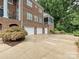 Back exterior of home with a three car garage and landscaped yard at 8623 Tullamore Park Cir, Charlotte, NC 28226