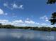 Beautiful lake view with blue sky, wispy clouds, and lush green trees at 8623 Tullamore Park Cir, Charlotte, NC 28226