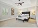 This main bedroom offers a tray ceiling, neutral walls, ceiling fan and great natural light at 8623 Tullamore Park Cir, Charlotte, NC 28226
