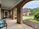Covered porch with brick arches overlooks the landscaped front yard at 8623 Tullamore Park Cir, Charlotte, NC 28226