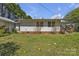 Home backyard with white siding, brick foundation, and green grass at 8974, 8972 & 8970 Nc 90 E Hwy, Stony Point, NC 28678