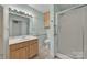Well-lit bathroom features tile floors, single vanity, large mirror, and glass-enclosed shower at 8974, 8972 & 8970 Nc 90 E Hwy, Stony Point, NC 28678