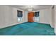 Large bedroom featuring teal carpet, crystal chandelier and natural light streaming in through windows at 8974, 8972 & 8970 Nc 90 E Hwy, Stony Point, NC 28678