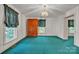 Bright bedroom boasting teal carpeting, natural light from window, and wooden storage cabinet at 8974, 8972 & 8970 Nc 90 E Hwy, Stony Point, NC 28678