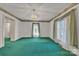 Spacious bedroom boasts teal carpet, natural light from the window, and decorative wallpaper border at 8974, 8972 & 8970 Nc 90 E Hwy, Stony Point, NC 28678