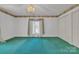 Cozy bedroom showcasing teal carpet, window, floral wallpaper border, and ample closet space at 8974, 8972 & 8970 Nc 90 E Hwy, Stony Point, NC 28678
