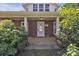 Inviting front porch with brick accents, decorative plants, and a clear view of the home's entrance at 8974, 8972 & 8970 Nc 90 E Hwy, Stony Point, NC 28678