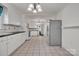 Open kitchen featuring tile floors, bright white cabinets, black countertops, and stainless steel appliances at 8974, 8972 & 8970 Nc 90 E Hwy, Stony Point, NC 28678