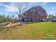 Expansive backyard showcasing lush greenery, a hot tub, and brick exterior, a private retreat at 9032 Cornflower Dr, Harrisburg, NC 28075