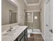 Modern bathroom with a glass-enclosed shower, wood floors and vanity at 9032 Cornflower Dr, Harrisburg, NC 28075