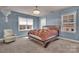 Inviting bedroom with large windows, chair, and ceiling fan; a relaxing retreat at 9032 Cornflower Dr, Harrisburg, NC 28075