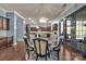 Open dining area with a glass table set and chandelier next to the kitchen at 9032 Cornflower Dr, Harrisburg, NC 28075