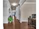 Inviting hallway with dark wood floors, white trim, and a chandelier at 9032 Cornflower Dr, Harrisburg, NC 28075