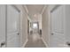 Hallway with tan walls, light brown flooring, white doors and trim at 9032 Cornflower Dr, Harrisburg, NC 28075