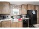 Modern kitchen with stainless steel sink, black appliances, and brick backsplash at 980 Lakeland Ave, Lincolnton, NC 28092