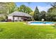 Expansive backyard featuring an in-ground pool, lush lawn, and comfortable lounge area at 10609 Washam Potts Rd, Cornelius, NC 28031