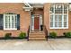 Charming front entrance with red brick facade, symmetrical windows, and inviting front door at 10609 Washam Potts Rd, Cornelius, NC 28031