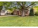 Charming brick home with mature trees, well-maintained landscaping, and a welcoming front porch at 10609 Washam Potts Rd, Cornelius, NC 28031