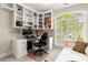 Dedicated home office with built-in shelving, large window with shutters, and computer setup at 10609 Washam Potts Rd, Cornelius, NC 28031