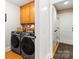 Modern laundry room equipped with new appliances, storage, and hardwood floors at 10609 Washam Potts Rd, Cornelius, NC 28031
