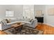 Bright living room showcasing a light grey sectional, dark wood coffee table, and hardwood floors at 10609 Washam Potts Rd, Cornelius, NC 28031
