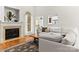 Living area with fireplace, light grey sectional, hardwood floors, and large windows at 10609 Washam Potts Rd, Cornelius, NC 28031