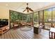 Relaxing screened porch with cozy seating, an outdoor fan, and a modern fire pit coffee table at 10609 Washam Potts Rd, Cornelius, NC 28031
