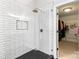 Shower featuring glass enclosure, white subway tile, black hexagon floor and walk in closet at 10609 Washam Potts Rd, Cornelius, NC 28031