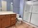A bathroom features a wood vanity with double sinks and a glass-enclosed shower at 10720 Hill Point Ct, Charlotte, NC 28262