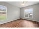 A bright bedroom with hardwood floors and two large windows allowing ample natural light at 10720 Hill Point Ct, Charlotte, NC 28262