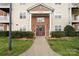Attractive condo building entrance featuring brick accents, lush landscaping and sidewalk at 10720 Hill Point Ct, Charlotte, NC 28262