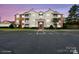 Residential condo building with a parking lot, a manicured lawn and an attractive sunset at 10720 Hill Point Ct, Charlotte, NC 28262