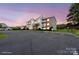 Dusk shot of a residential condo building with a spacious parking lot and an attractive sunset at 10720 Hill Point Ct, Charlotte, NC 28262