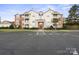 Exterior of a residential condo building showing a parking lot and manicured lawn at 10720 Hill Point Ct, Charlotte, NC 28262