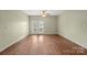 Bright living room featuring wood floors, ceiling fan, and access to a private balcony at 10720 Hill Point Ct, Charlotte, NC 28262