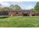 Brick home's backyard features a gazebo, grill, trampoline, and grassy area at 1121 Rembrandt Sw Dr, Concord, NC 28027