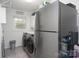 Laundry room featuring stainless steel appliances, overhead storage, and a window at 1121 Rembrandt Sw Dr, Concord, NC 28027