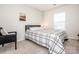 Cozy bedroom with a modern accent chair, neutral walls, and a window offering natural light at 123 Abersham Dr, Mooresville, NC 28115