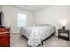 Neutral bedroom features a patterned gray quilt, a dresser, and natural light from a window at 123 Abersham Dr, Mooresville, NC 28115