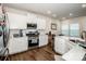Bright kitchen featuring white cabinets, stainless steel appliances, and hardwood flooring with ample counter space at 123 Abersham Dr, Mooresville, NC 28115