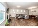 Bright living room with hardwood floors, a fireplace, a gray sectional sofa, and dining area in view at 123 Abersham Dr, Mooresville, NC 28115