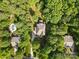 Aerial view of a home nestled among mature trees, featuring a circular pool and long driveway at 1320 Huntcliff Dr, Waxhaw, NC 28173