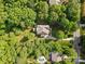 An aerial view showcases a home surrounded by lush trees, a pool and verdant landscaping at 1320 Huntcliff Dr, Waxhaw, NC 28173