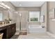 A bathroom featuring a vanity with granite countertops, a soaking tub, and a glass-enclosed shower at 1320 Huntcliff Dr, Waxhaw, NC 28173