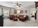 This comfortable living room features a leather sofa, ceiling fan, and lots of natural light at 1320 Huntcliff Dr, Waxhaw, NC 28173