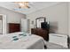 This main bedroom features wood furniture, a ceiling fan, and neutral colored walls at 1320 Huntcliff Dr, Waxhaw, NC 28173