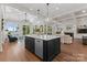 Gourmet kitchen and living area with an island, and views to the lake through large windows, creating a serene atmosphere at 1328 Astoria Pkwy, Catawba, NC 28609