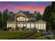 Expansive rear exterior featuring a patio, large windows, lush lawn, and a peaceful view of the surrounding trees at 1328 Astoria Pkwy, Catawba, NC 28609