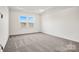 Spacious bedroom with soft carpeting, a tray ceiling and a large window at 13756 Roderick Dr # 176, Huntersville, NC 28078
